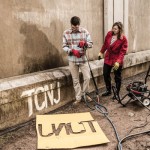 two people spray painting TCNJ on wall