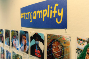 gallery wall with #tcnjamplify sign above